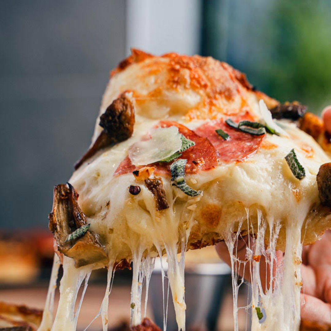 Hemi Pizza cheese pull - Detroit-style slice with stretching mozzarella